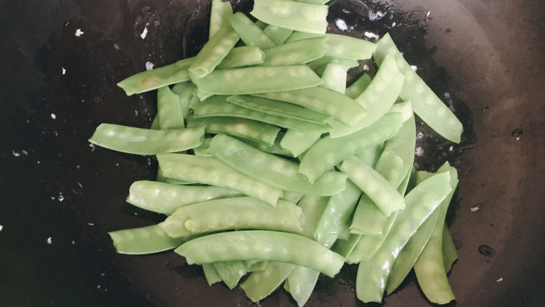 荷兰豆炒鸡蛋,锅下薄油，下焯水后的荷兰豆翻炒1~2分钟