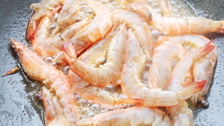 花海游虾,热锅后加入食用油,六七层热时加入虾煎制一下。