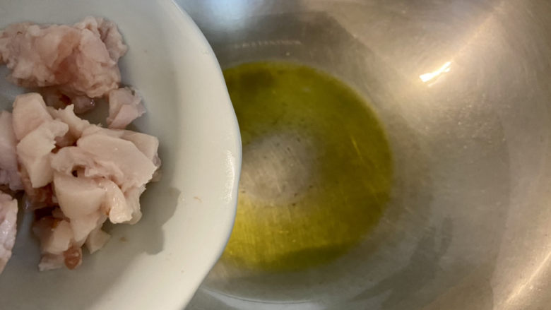 小白菜肉丝面,烧水煮面时可以同时炒浇头,热锅凉油,先下肥肉丁煸炒金黄微焦,再下肉丝滑炒变色