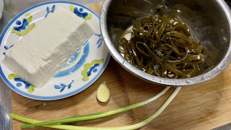 海带豆腐汤,海带清洗,内脂豆腐去包装,小葱择好洗净,姜搓洗干净