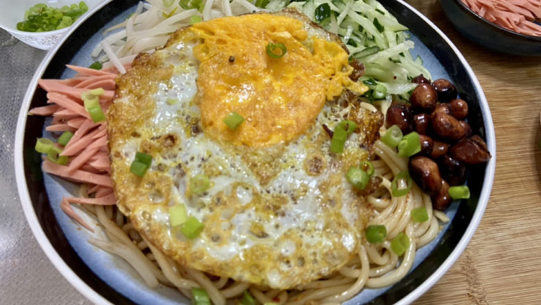 黄瓜拌面,最后码上火腿丝,黄瓜丝,绿豆芽,花生米,煎蛋,撒上葱末即可拌匀食用
