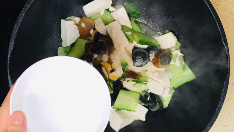 皮蛋豆腐汤,加入半碗清水,转中火,慢火熬煮