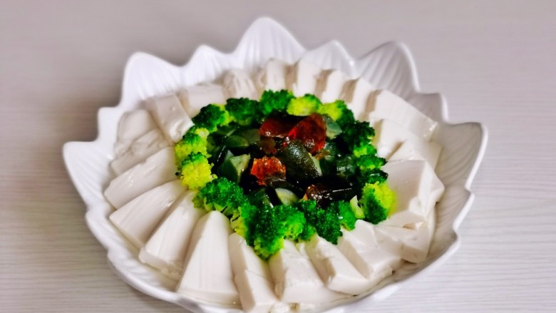 皮蛋豆腐汤,豆腐片摆在盘子一圈,皮蛋中间,再围上一圈西兰花。