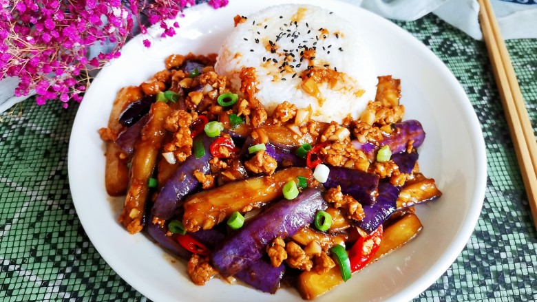 鱼香茄子盖饭,再把炒好鱼香茄子也盛入盘中，米饭上撒少许黑芝麻点缀即可