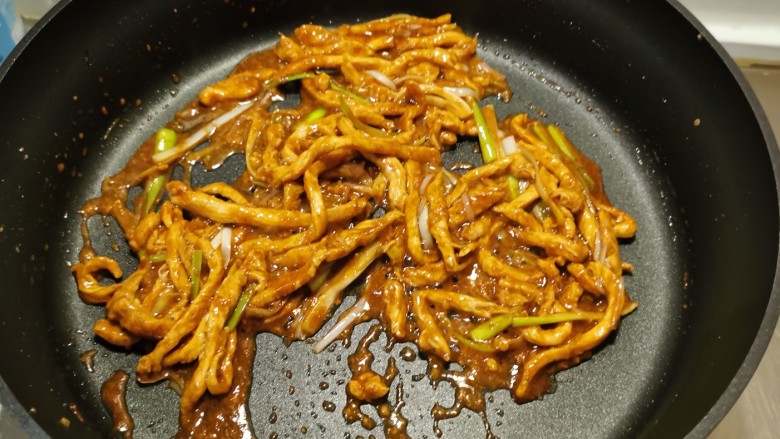 葱爆肉丝,加入酱油提味,翻炒均匀。