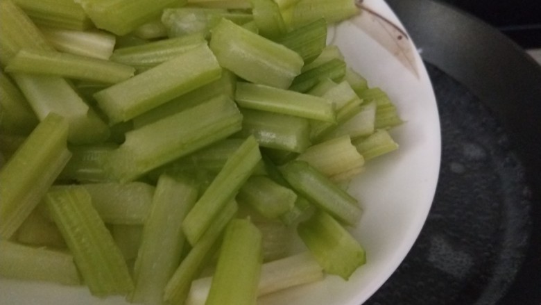 西芹炒香干,锅中倒入适量水烧开倒入芹菜。