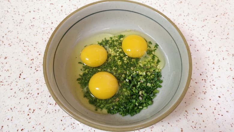 野菜鸡蛋饼,将小蒜碎放入大碗里,打入<a style='color:red;display:inline-block;' href='/shicai/ 9'>鸡蛋</a>。