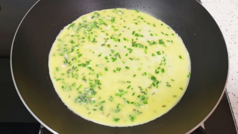 野菜鸡蛋饼,平底锅刷上一层食用油烧热,倒入一勺小蒜鸡蛋液,来回晃一下锅子,使蛋液均匀的铺在锅底。