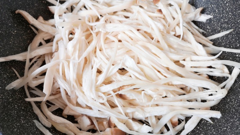 干煸手撕杏鲍菇,炒锅烧热(记住不用放油),下入撕好的杏鲍菇。