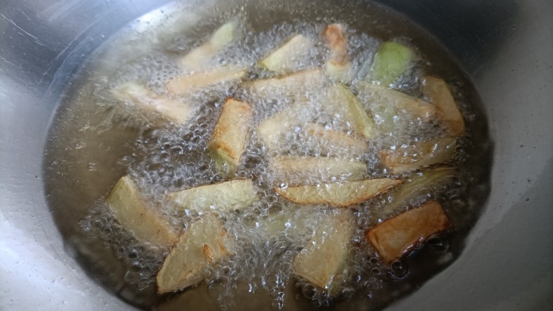 鱼香茄子盖饭,锅内倒入油，油的高度和茄子差不多齐平就可以。烧到五六成热，分次下茄条炸