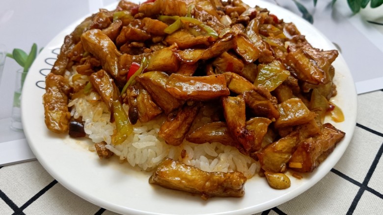 鱼香茄子盖饭,把米饭盛在盘子里,舀上几勺茄条,鱼香茄子盖饭就完成了,超级下饭。