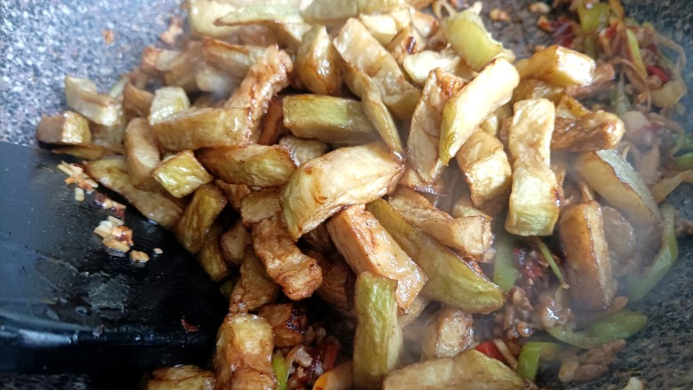 鱼香茄子盖饭,再把茄条倒进锅中,一起炒匀。