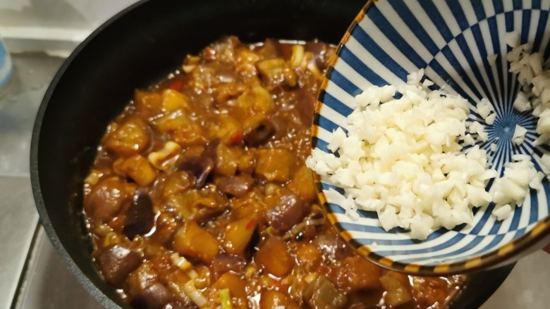鱼香茄子盖饭,加入蒜碎翻拌,大火收汁,关火出锅。