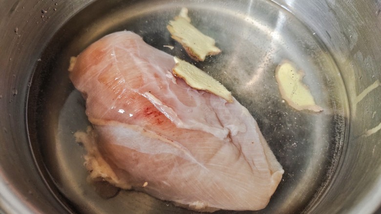鸡丝凉面,锅种加水,放入鸡胸肉,生姜片