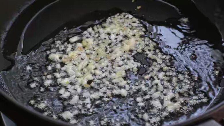 葱爆虾仁,锅中倒适量食用油烧至五成热,放入姜末和一半的蒜末小火炒香。
