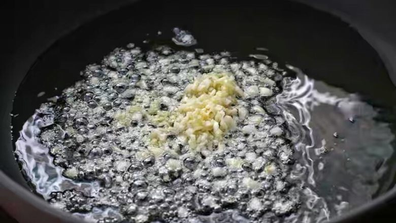 菠萝炒鸡,锅中倒适量食用油烧至五成热,放入姜、蒜末小火炒香。