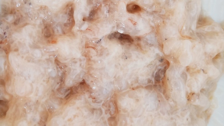 珍珠白玉汤,剁好的虾仁放入碗中,加入一勺料酒和半勺鸡汁,再加入适量生粉,顺着一个方向搅拌上劲儿。