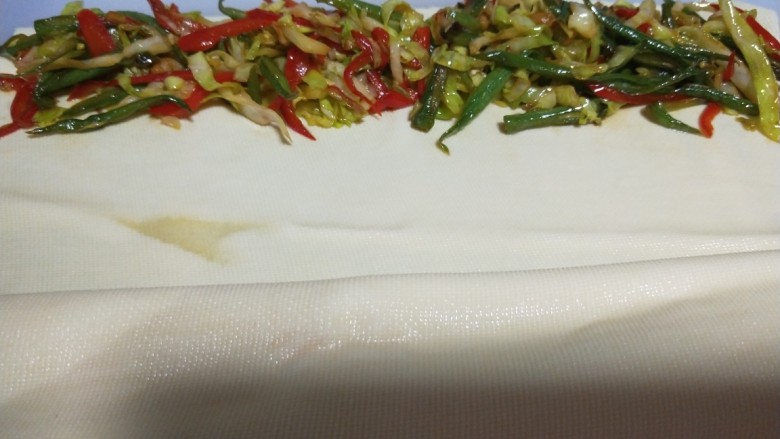 素卷三丝,将豆皮铺开,炒好的三丝均匀的码在豆皮上