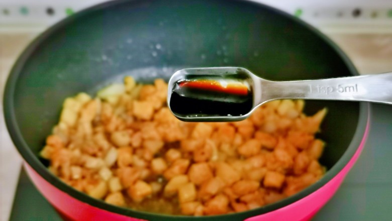 杏鲍菇炒鸡丁,再加入一勺生抽,把鸡丁炒熟。