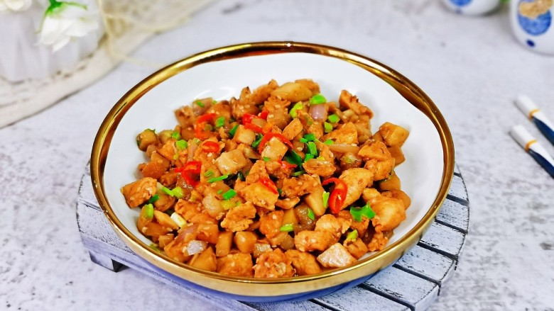 杏鲍菇炒鸡丁,盛出装盘,点缀上葱花与辣辣段。