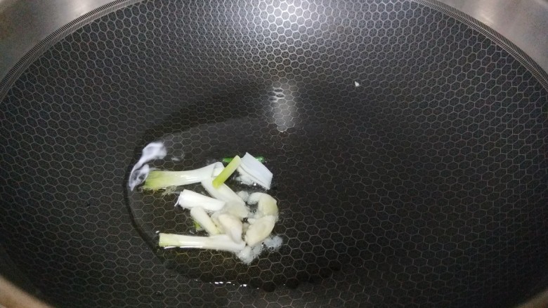 白菜炒蘑菇,锅中倒入适量油烧热,把葱白放入锅中炒香。