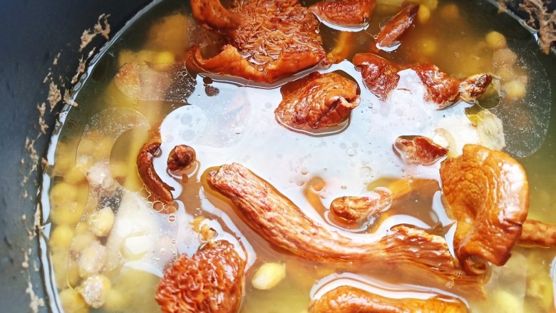 蘑菇鸡肉浓汤,将清洗好的蘑菇放入炖好的土鸡汤中,再炖一会儿。
