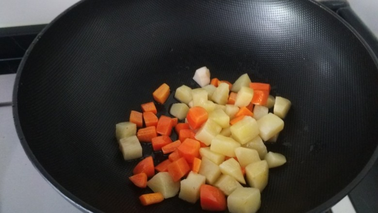 杏鲍菇炒鸡丁,锅中烧油下入胡萝卜,土豆丁