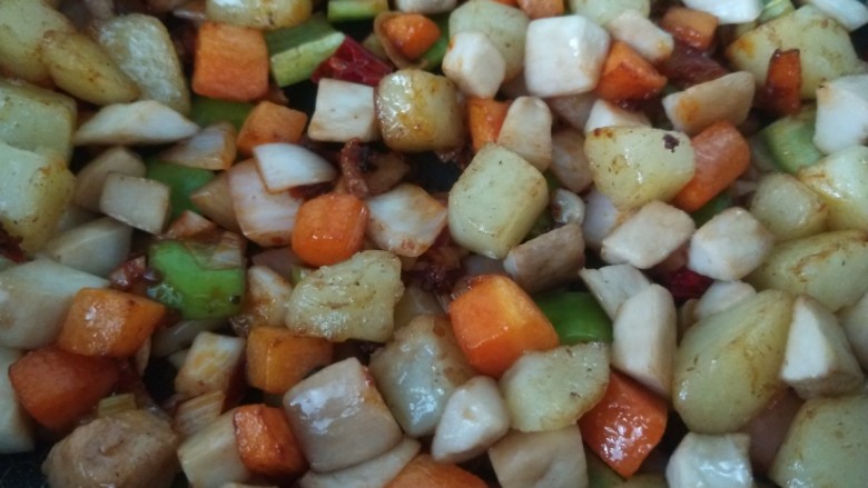 杏鲍菇炒鸡丁,最后将土豆,胡萝卜,杏鲍菇丁一起放进去进行翻炒