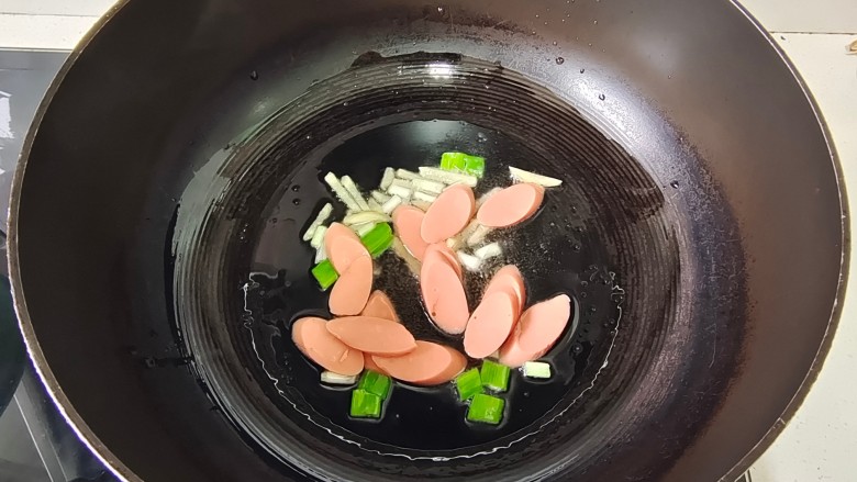 蚝油土豆片,炒锅中加入适量花生油烧热,放入葱姜爆香,加入火腿肠片翻炒片刻