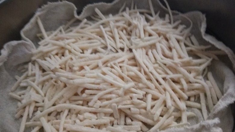 山西小吃炒不烂子,干屉布铺在蒸屉,土豆丝要沾均匀面粉在放入蒸屉蒸15分钟。