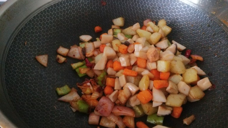 杏鲍菇炒鸡丁,,在倒入胡萝卜,土豆,杏鲍菇。