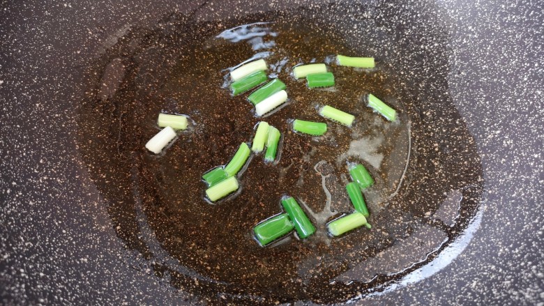 木耳炒粉丝,炒锅内倒适量的食用油烧热,下入葱段炝香。