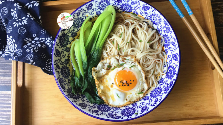 青菜鸡蛋面,将煎好的鸡蛋摆放在上面,最后撒上葱花和黑芝麻