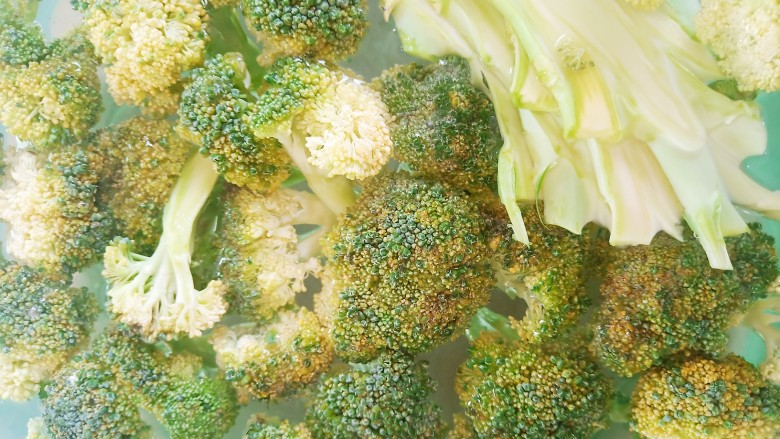 凉拌蒜蓉西兰花,盆中加入适量清水和食盐,加入西兰花浸泡清洗干净。