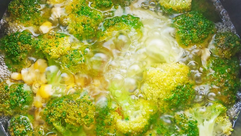 凉拌蒜蓉西兰花,锅中加入清水,适量食盐和食用油,水开后加入西兰花,胡萝卜,玉米粒焯水2分钟。