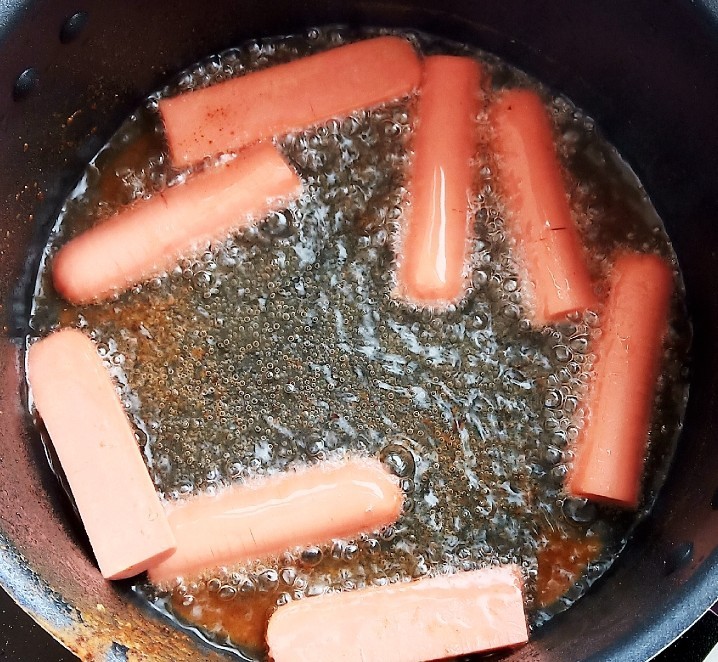 肠肠久久,连年有鱼,锅中烧油,放入火腿肠煎炸。