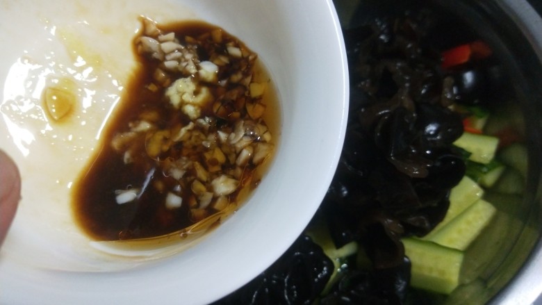 黄瓜拌木耳,提前把蒜拍扁剁碎,酱油,醋,鸡精,盐,香油调成汁倒入盆中。