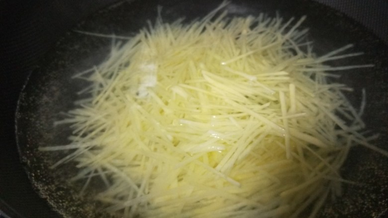 老干妈拌土豆丝,倒入土豆丝加入适量盐,一分钟捞出来。