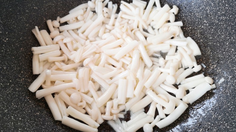 海鲜菇豆腐汤,炒锅内倒适量的食用油烧热,下入海鲜菇翻炒至变软。