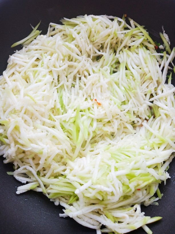 清炒蒲瓜丝,加入蒲瓜丝翻炒均匀,炒出水汽。