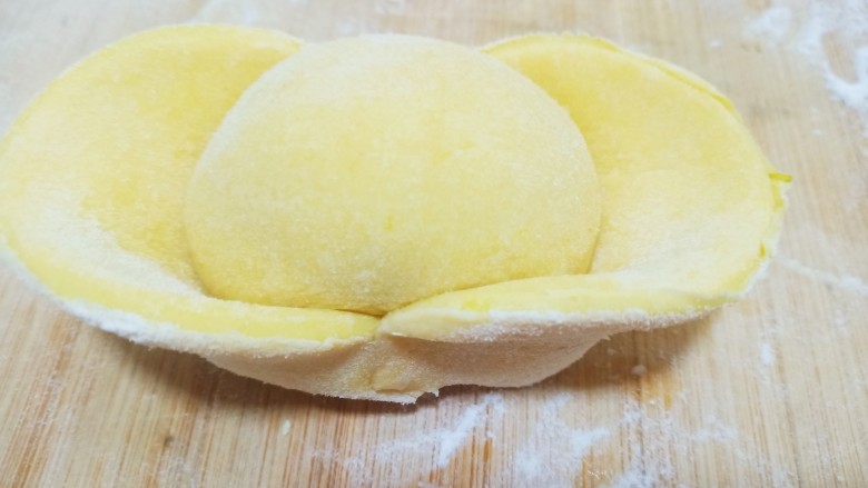 杂粮包子,在切面涂上适量清水，沾在刚才做好的豆沙包上，一个漂亮的金元宝就做好了。