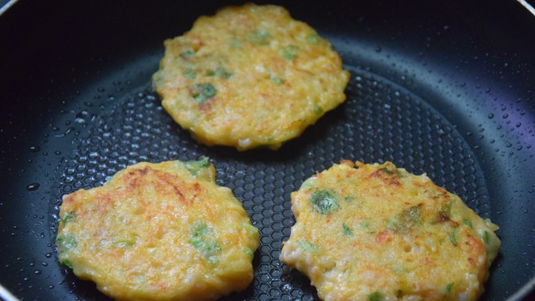 鲜虾蔬菜饼,待虾饼凝结,翻面继续煎熟即可