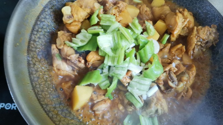咖喱土豆鸡块,煮汤汁收干,土豆软烂,下入青椒,大蒜和葱翻炒几下