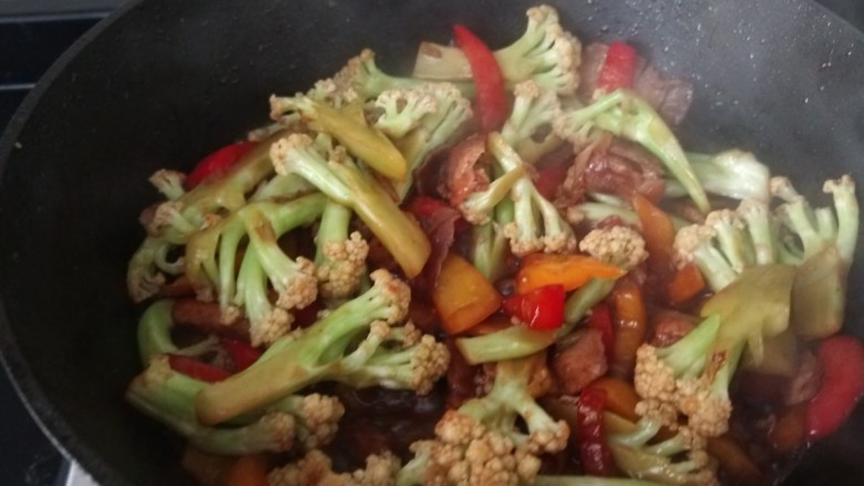 干锅菜花五花肉,大火进行翻炒,翻炒时一次少量加入白开水,这样菜花更容易熟,翻炒3到5分钟即可出锅
