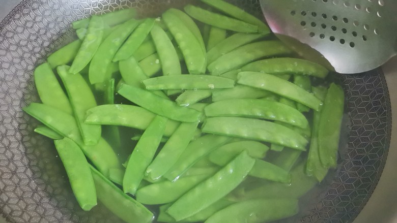 肉片炒荷兰豆,锅里烧水加入适量的油和盐，水开下入荷兰豆焯水30秒捞出控干水分