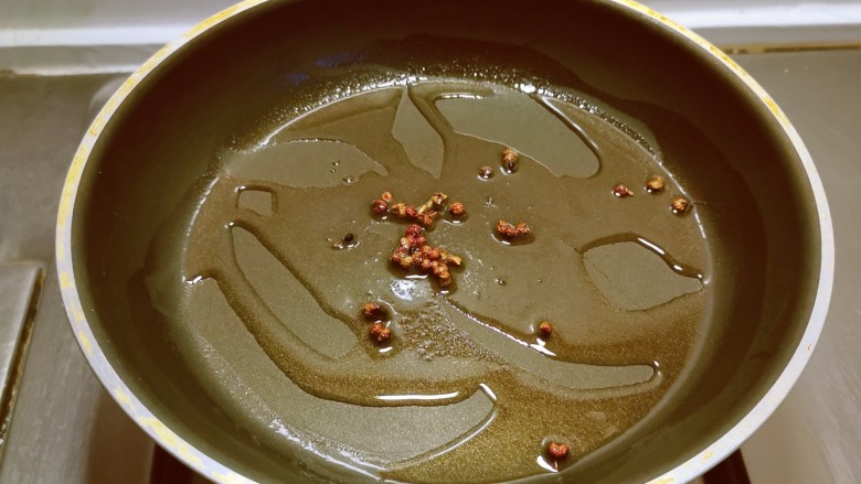 椒麻手撕鸡,起油锅放入食用油,油热后放入麻椒爆香。
