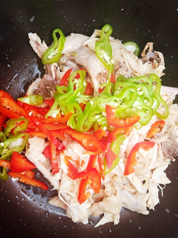 椒麻手撕鸡,浸泡过的鸡肉撕成小块,再加入青红椒丝。