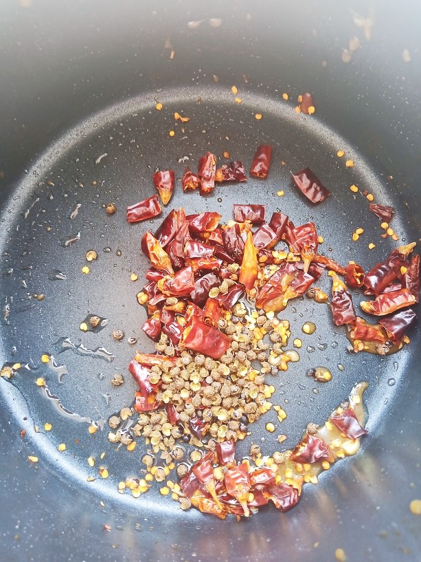 椒麻手撕鸡,锅中烧油,加入适量花椒和<a style='color:red;display:inline-block;' href='/shicai/ 86474'>干辣椒</a>炒出香气。
