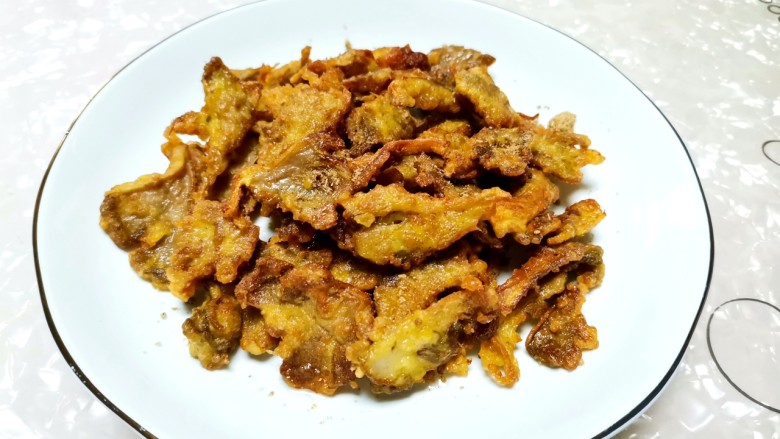 酥炸蘑菇,第一次炸好后,油锅加热,进行第二次复炸30秒