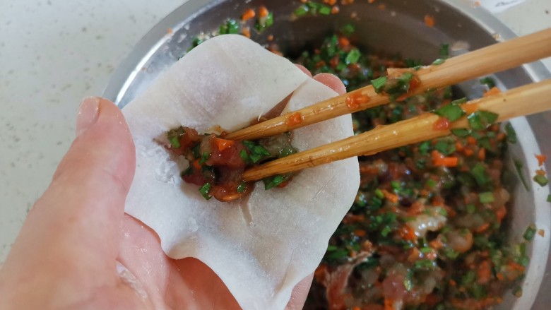 海鲜小馄饨,取一个馄饨皮,夹适量的肉馅